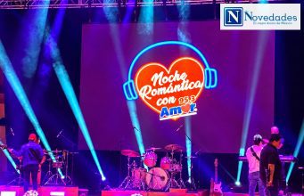 Pandora y Fey en El Cantoral: Noche Romántica con Amor 95.3 Pantalla de Noche Romántica con Amor 95.3 sobre el escenario iluminado.